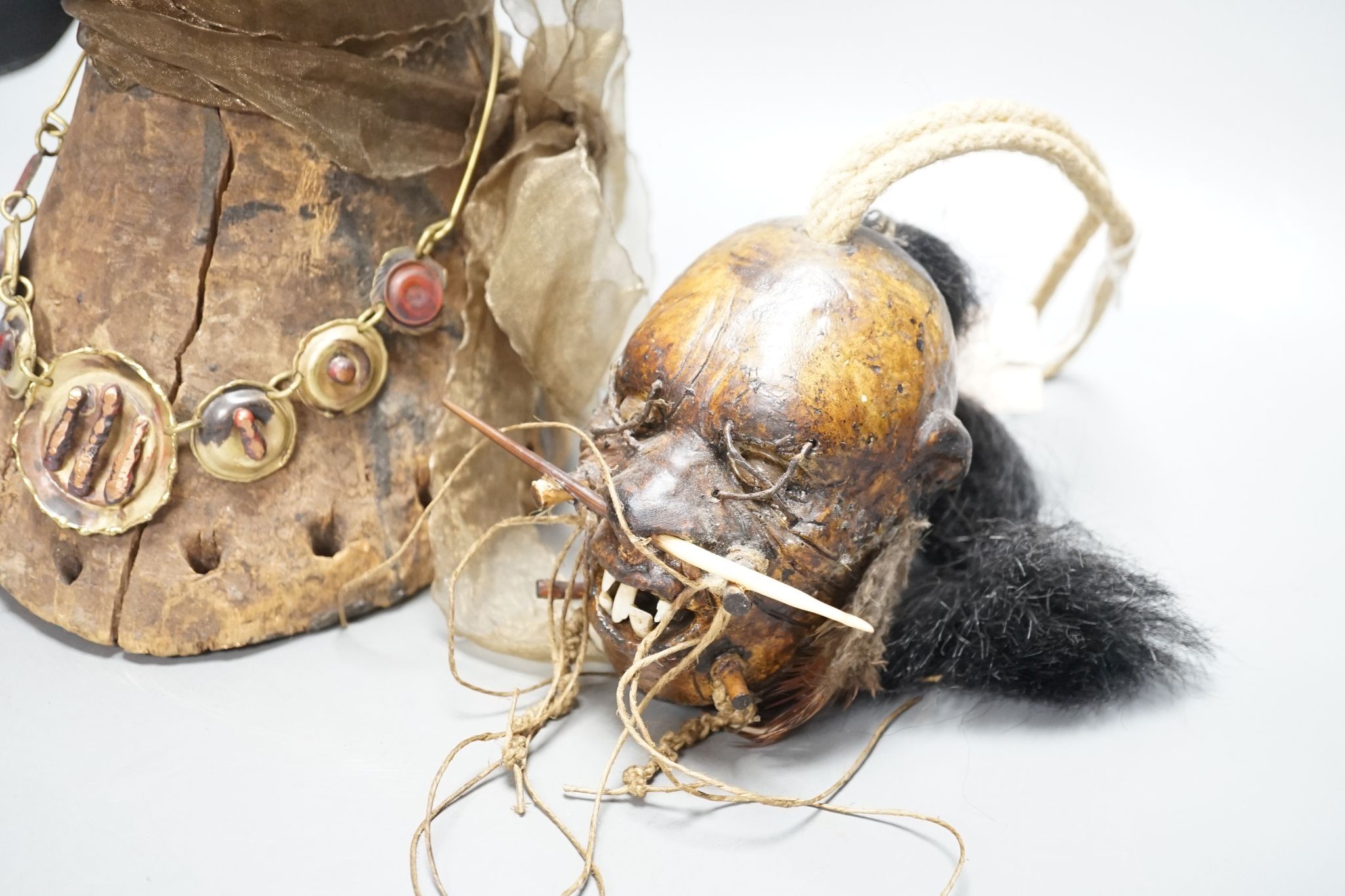 An African tribal carving, 31cm and a pottery model of a shrunken head